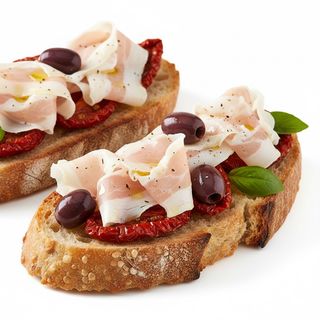 Bruschetta con il lardo di colonnata, pomodori secchi e olive taggiasche