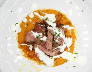 Medaglione di manzo al pesto di peperoni e nocciole su carote caramellate e yogurt