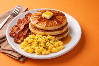 American breakfast - pancakes e sciroppo acero, bacon e uova strapazzate