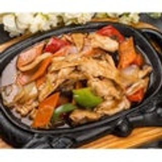 Maiale saltato con le verdure sulla piastra