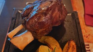 Stinco di maiale con patate al forno