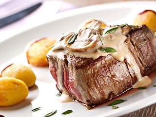 Biftek (300r) u šampinjon sosu sa prilogom