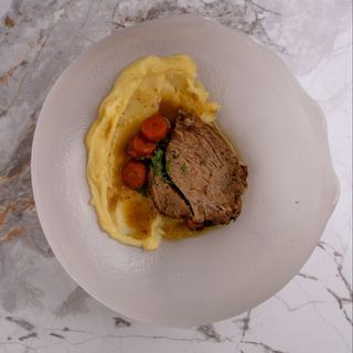 Бавно печено и топящо се свинско, поднесено с червени чушки