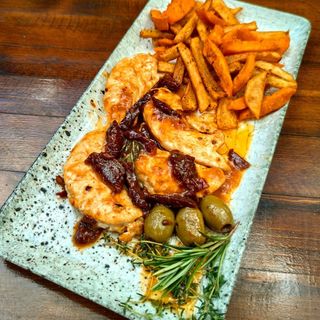 Крехки пилешки бон филенца с лек пикантен сос, гарнирани с пръчици от сладък и бял картоф