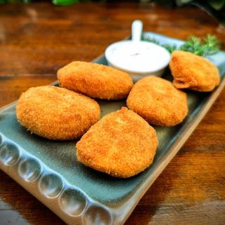 Хрупкави бобени кюфтенца с печени червени чушки и сушени домати,поднесени с млечен сос