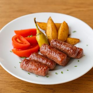 Телешки кебапчета с Уеджис картофки, пресен домат и лютеница 350 гр.