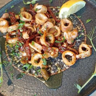 Задушени бейби калмари с бяло вино, магданоз и чесън (250г)