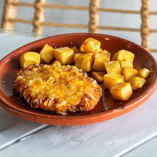 Milanesa de pollo rellena de bacon y queso, gratinada con napolitana, quesos fundidos y parmesano