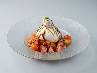 Burrata de leche de oveja, selección de tomates y pipas garrapiñadas.