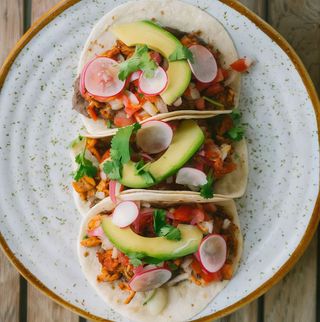 Tacos de pollo pibil con aguacate, frijoles refritos y cilantro