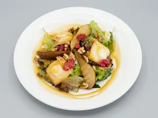 Ensalada de queso de cabra en tosta caliente, pera caramelizada y nueces.