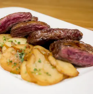 Entraña a la plancha con patatas panaderas.