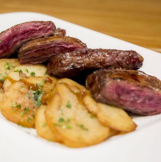 Entraña a la plancha con patatas panaderas.