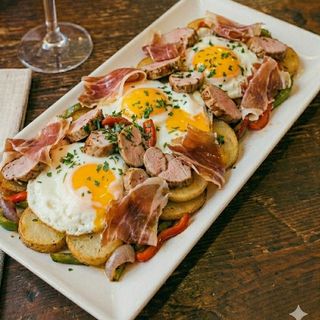 Huevos rotos con patatas, solomillo de cerdo y jamón Ibérico