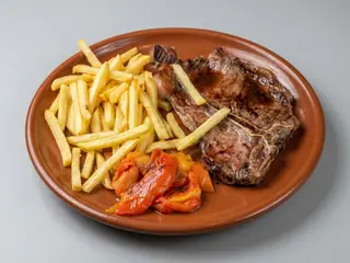 Chuleta De Ternera Con Patatas Y Pimientos