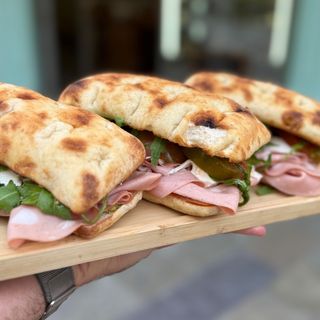 Focaccia Mortadella, mozzarella, tomate y rucola con aceite al pesto