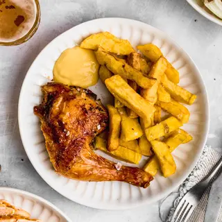 Muslo de pollo a la brasa con guarnición