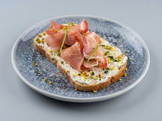  Bruschetta Con Jamon serano, queso crema y pistachos picados