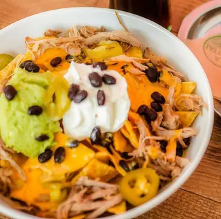 Nachos con salsa picante, cheddar y guacamole