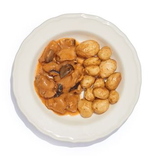 Contramuslos de pollo deshuesados en salsa con patatas rústidas caliente