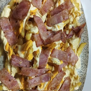 Patatas crujientes con bacón y salsa cheddar y ranchera