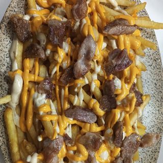 Patatas crujientes con secreto ibérico ( salsa cheddar y ranchera )