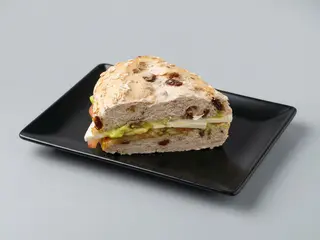 Pan con avena y pasas con tomate, guacamole y queso tierno