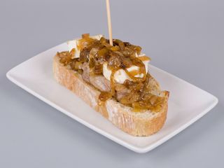 Presa De Cerdo Con Rulo De Cabra Y Cebolla Caramelizada