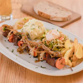 Brocheta de Pollo Cajún con Ensaladas Alemanas y Papas Fritas