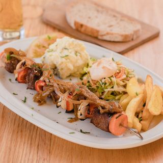 Brocheta de Pollo Cajún con Ensaladas Alemanas y Papas Fritas