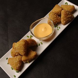 Nachos rellenos de guacamole con salsa de queso