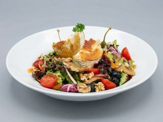 Ensalada gourmet con queso de cabra tostado salsa de frutas del bosque