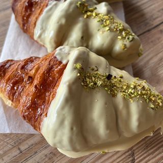 Cruasán con cobertura de chocolate de pistacho.