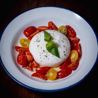 Burrata con tomatitos cherrys y albahaca