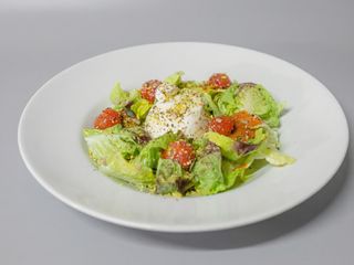 Ensalada burrata con tres tipos de tomate y pistacho
