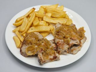 Secreto de cerdo con cebolla caramelizada acompañado con papas fritas