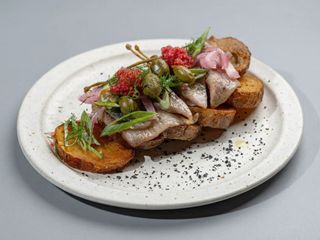 Herring served on a deep fried potato pillow with marinated onion