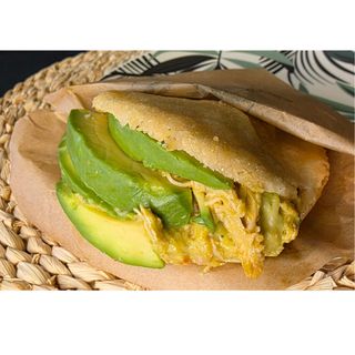 Arepa frita rellena con aguacate y pollo.