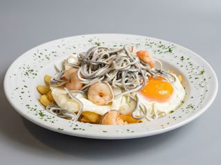 Huevos rotos con gulas y gambas al ajillo