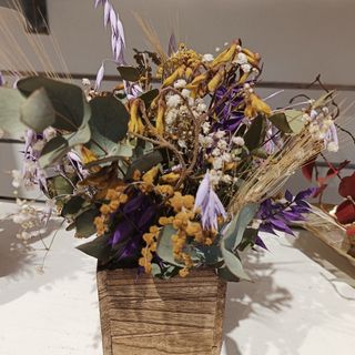 Caja de madera marrón con flores secas y preservadas
