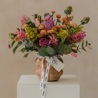 Jarrón cerámico con flores variadas estilo asilvestrado