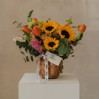 Jarrón cerámico con flores variadas y girasoles