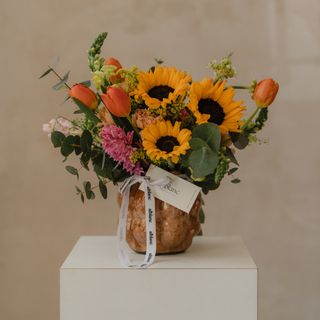 Jarrón cerámico con flores variadas y girasoles