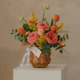 Jarrón cerámico con flores variadas y rosas inglesas