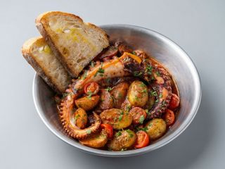 Tentáculos de pulpo al estilo siciliano con tomates y papas nuevas 