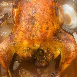 Pollo asado al horno con patas fritas y salsa romesco.