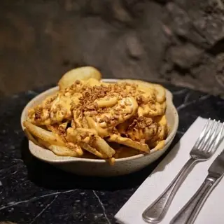 Patatas bravaoli con cebolla frita.