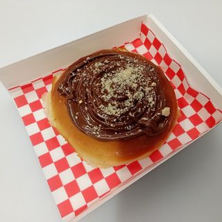 Roll de canela con topping de Nutella y avellanas troceadas.