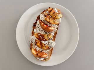 Tostada de queso crema y melocotón natural con miel y frutos secos 