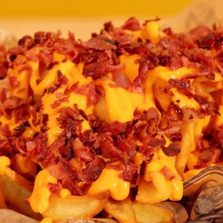 Patatas con jamón serrano,salsa cheddar y cebolla crujiente